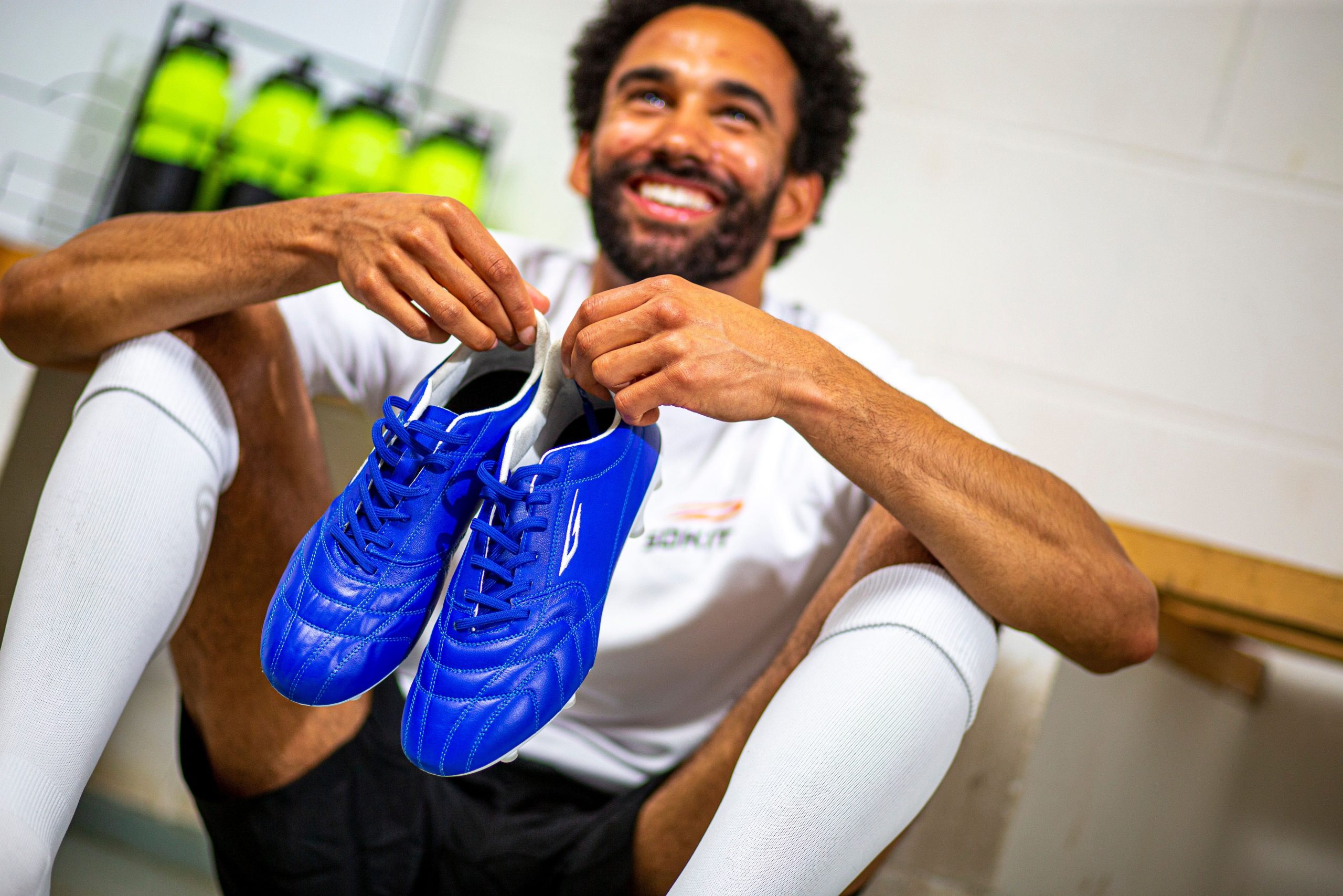 Player holding sokito sustainable Devista football boots